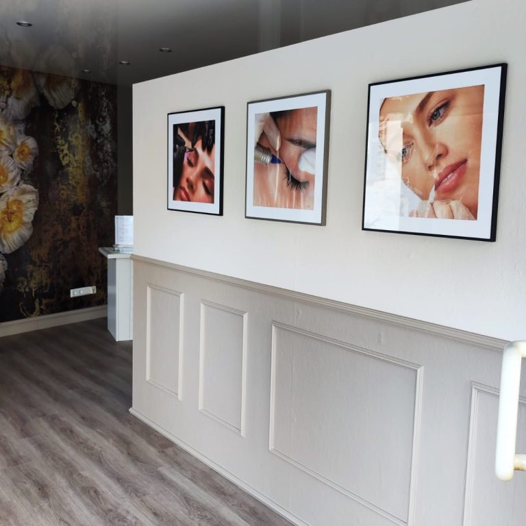 Wand mit Portraits Wand mit drei gerahmten Portraits von Augen und Gesicht in modernem Raum.